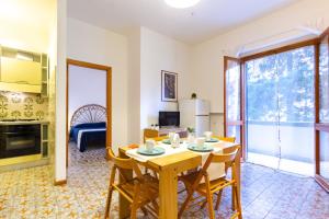 ein Wohnzimmer mit einem Tisch und Stühlen sowie eine Küche in der Unterkunft Appartamento La Poesia Bilo 2 - MyHo Casa in Tortoreto Lido