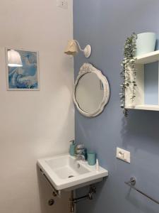 La salle de bains est pourvue d'un lavabo et d'un miroir. dans l'établissement B&B L'OFFICINA DEI SOGNI, à Poggio Morello