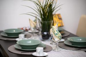 a table with green plates and glasses on it at Wanderer 3 in Debrecen
