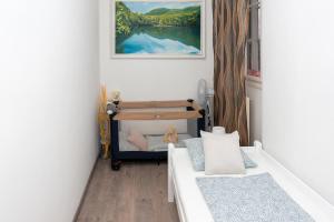 ein kleines Schlafzimmer mit einem Bett und einem Gemälde in der Unterkunft Wanderer 3 in Debrecen