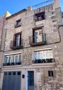 an old stone building with windows and balconies at Cals iaios in Villalba dels Arcs +16 photos