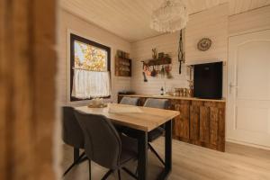 uma sala de jantar com uma mesa e cadeiras e uma televisão em Organicle Lodge em Sîncrăieni