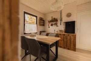 a dining room with a table and chairs and a television at Organicle Lodge in Sîncrăieni +23 photos