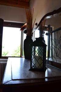 dois vasos e uma lanterna sentados numa mesa em Agriturismo La Casa in Collina 