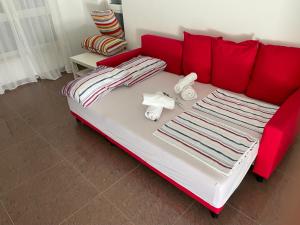 a red couch with towels on it in a room at Apartment Volme Inventum in Banjole