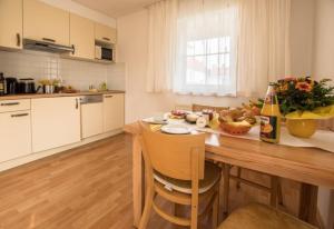eine Küche mit einem Holztisch und einer Flasche Champagner in der Unterkunft Ferienwohnung Pilsensee in Herrsching am Ammersee