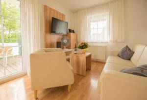 ein Wohnzimmer mit einem Sofa und einem TV in der Unterkunft Ferienwohnung Pilsensee in Herrsching am Ammersee