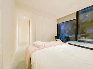 a white room with a bed and a large window at Pyrmont Town House Homestay in Sydney