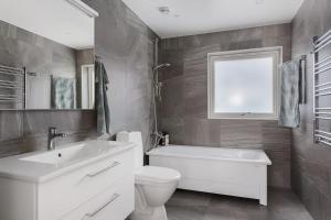 a bathroom with a sink and a toilet and a window at Modernt hus med parkeringsplatser och trädgård in Gothenburg