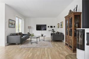 uma sala de estar com sofás e uma televisão de ecrã plano em Modernt hus med parkeringsplatser och trädgård em Gotemburgo