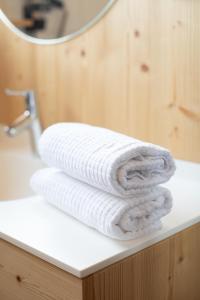 einen Stapel Handtücher auf einer Badezimmertheke in der Unterkunft Pension Örtlerhof in Dorf Tirol