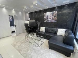 a living room with a black couch and a table at Luxury Central Apartment Verila in Sofia