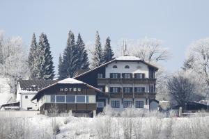 un hôtel en hiver avec de la neige au sol dans l'établissement Landhotel Gottinger, à Waldkirchen
