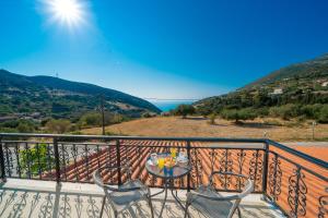 einen Balkon mit einem Tisch und Stühlen sowie Meerblick in der Unterkunft Myrtos View Apartments in Anomeriá