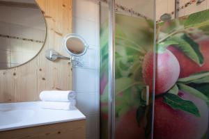 ein Badezimmer mit einer Dusche und einem Apfelgemälde in der Unterkunft Pension Örtlerhof in Dorf Tirol