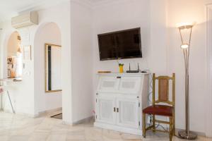 a living room with a tv on a white wall at Stella Maris B4 3A Nerja in Nerja