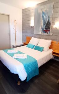 sypialnia z dużym łóżkiem z niebieską i białą pościelą w obiekcie Le Saint Vincent w mieście Apremont