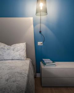 a bedroom with a bed and a light on a blue wall at AZIENDA AGRICOLA MOSCHIONI in Cividale del Friuli