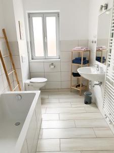 ein Badezimmer mit einer Badewanne, einem WC und einem Waschbecken in der Unterkunft Weinquartier Naumburg in Naumburg