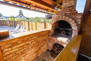 an outdoor brick oven with a bench on a patio at Apartments Galunder in Veržej