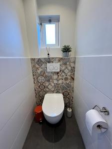een badkamer met een wit toilet en een raam bij De Molen in Zierikzee