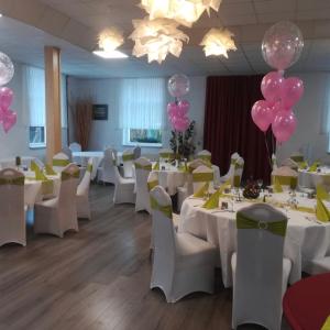 una sala de banquetes con mesas blancas y globos rosados en Lindenhof Liepgarten - Pension & Gaststätte, en Ueckermünde