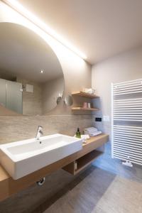 ein Badezimmer mit einem weißen Waschbecken und einem Spiegel in der Unterkunft Pension Örtlerhof in Dorf Tirol