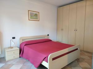 ein Schlafzimmer mit einem Bett mit einer rosa Decke in der Unterkunft La casa di Giovanni in Como