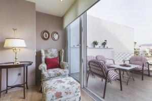 un soggiorno con sedia e tavolo con sedie di Luxury Acropolis View Duplex Penthouse in Thiseio 155m2 ad Atene
