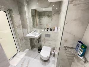 a white bathroom with a toilet and a sink at Luxury Central Apartment Verila in Sofia