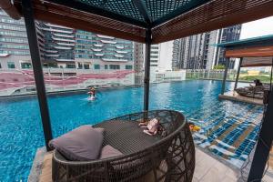 - une piscine avec une chaise au milieu dans l'établissement Reizz Residence By Minsu, à Kuala Lumpur