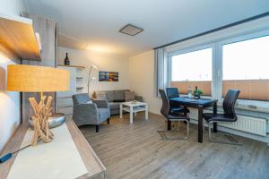 een woonkamer met een tafel en stoelen en een bank bij Beachlife in Westerland