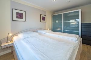 een groot wit bed in een kamer met een raam bij Beachlife in Westerland