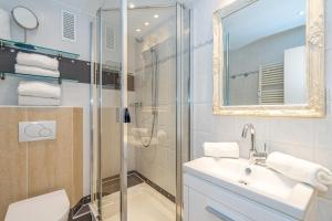 een badkamer met douche, wastafel en spiegel bij Beachlife in Westerland +9 foto's