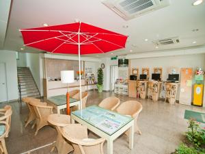 uma mesa com um guarda-chuva vermelho num quarto em Hotel Good Inn em Seogwipo