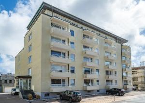 een appartementengebouw met ervoor geparkeerde auto's bij Beachlife in Westerland