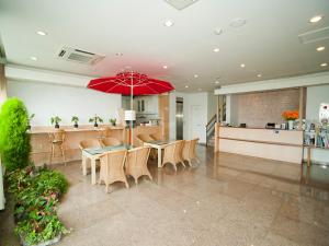 西歸浦的住宿－Hotel Good Inn，一间带红色遮阳伞的餐桌的用餐室