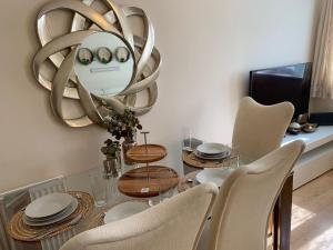 a dining room with a table with chairs and a mirror at Modern Flat in Watford
