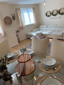 a living room with a glass table and chairs at Modern Flat in Watford