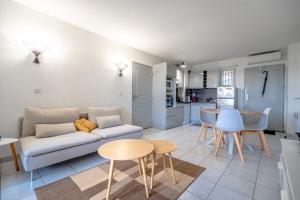 ein Wohnzimmer mit einem Sofa und einem Tisch in der Unterkunft Superbe Appartement avec Piscine in Plan-de-la-Tour