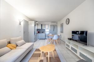 普朗德拉圖爾的住宿－Superbe Appartement avec Piscine，客厅配有白色沙发和电视
