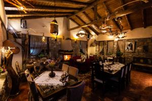 ein Restaurant mit Tischen, Stühlen und einem Kamin in der Unterkunft La Moara Boutique Hotel in Kraniá