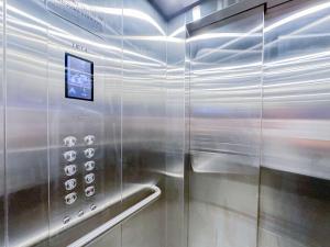 a stainless steel elevator with a sign on it at Pyrmont Town House Homestay in Sydney