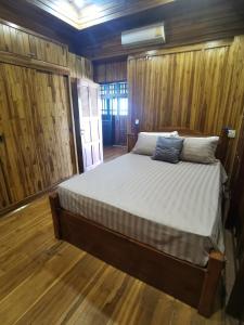 a large bed in a room with wooden floors at Thai traditional wooden house in Ban Nong Bu