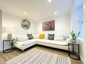 a white living room with a white couch and two tables at Stunning Loft Apartment South Queensferry High St Bridge Views! in Queensferry