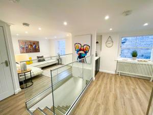 una sala de estar con una escalera de cristal en una casa en Stunning Loft Apartment South Queensferry High St Bridge Views!, en Queensferry