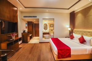 a hotel room with a large bed and a bathroom at Regenta Place Jhansi by Royal Orchid Hotels Limited in Jhānsi