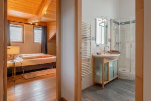 ein Bad mit einem Waschbecken und ein Bett in einem Zimmer in der Unterkunft Ski Dome Apartments & Heaven Holiday Chalet in Kaprun