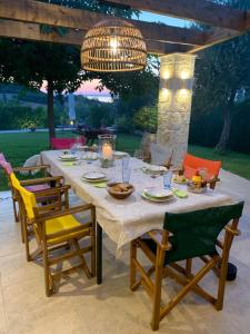 a dining table with chairs and a chandelier at Villa Helios in Pefkochori