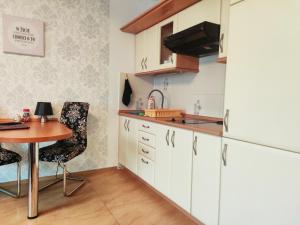 a kitchen with a table and a refrigerator at Apartament Klonowa in Kołobrzeg